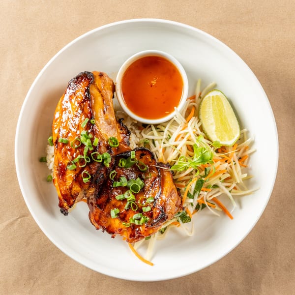 Orienta Restaurant's Asian-fusion grilled chicken with rice, slaw, lime, and dipping sauce.