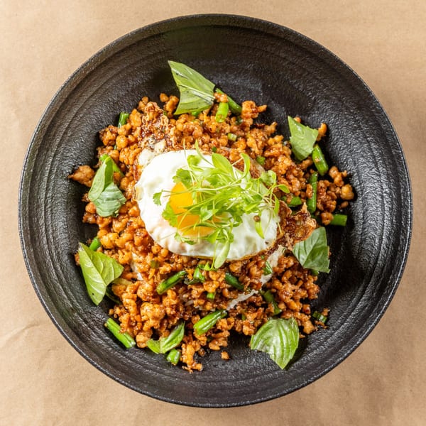 Orienta's Asian-fusion dish with minced meat, green beans, basil, and a fried egg.